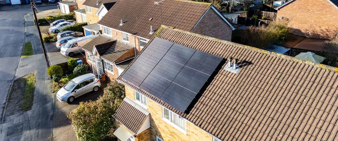 Black solar panels neatly fitted to a UK tiled house roof